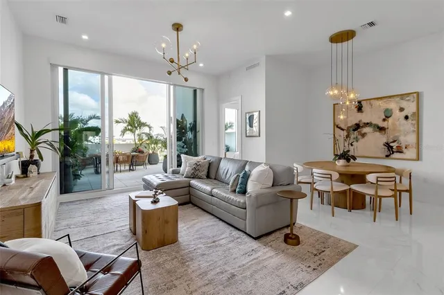 a living room with furniture a chandelier and a large window
