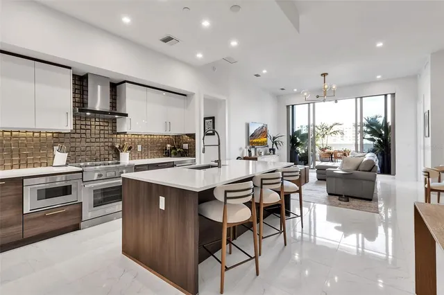 a kitchen with stainless steel appliances kitchen island granite countertop a stove and a refrigerator