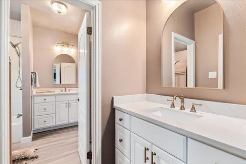 a en suite bathroom with a double vanity sink and a mirror