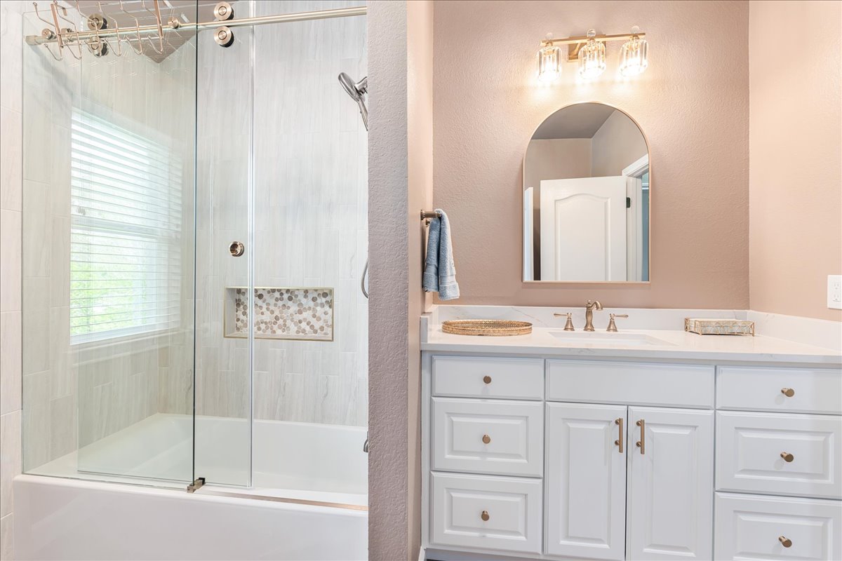 58 Cottondale Road The Hills, TX 78738 - Photo 26 of 40 a bathroom with a bathtub a shower a sink and mirror