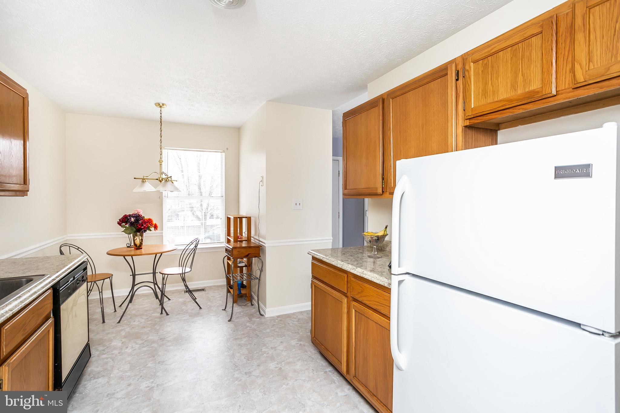 615 Nollmeyer Road Baltimore, MD 21220 - Photo 7 of 46 a kitchen with a refrigerator a stove and a dining table