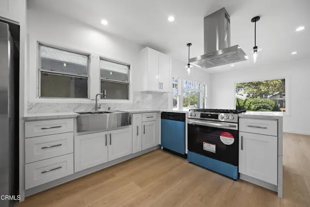 a kitchen with stainless steel appliances kitchen island granite countertop a stove and a sink