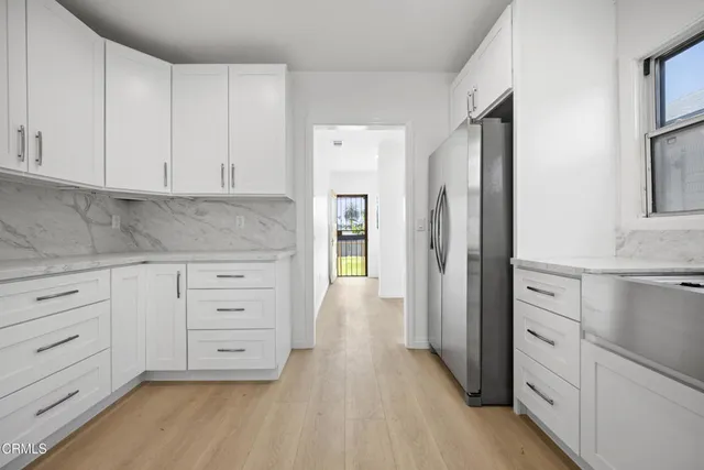 a kitchen with white cabinets and stainless steel appliances