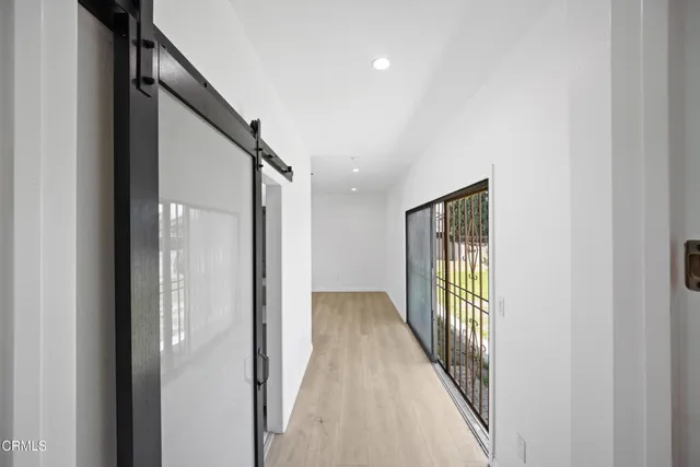 a view of a hallway with wooden floor and stairs