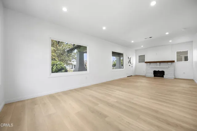 a view of empty room with fireplace and window