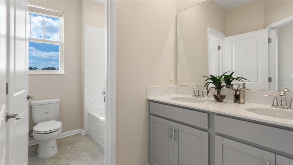 2575 Rider Rain Lane Apopka, FL 32703 - Photo 12 of 19 a bathroom with a granite countertop sink a toilet and a mirror