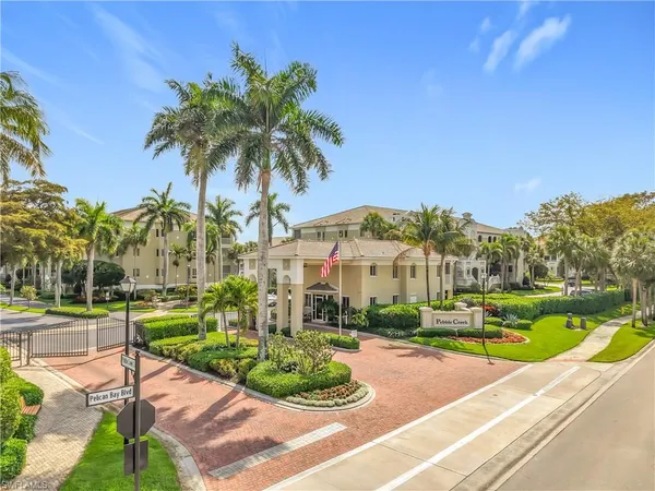 a view of a white house with a yard table and chairs
