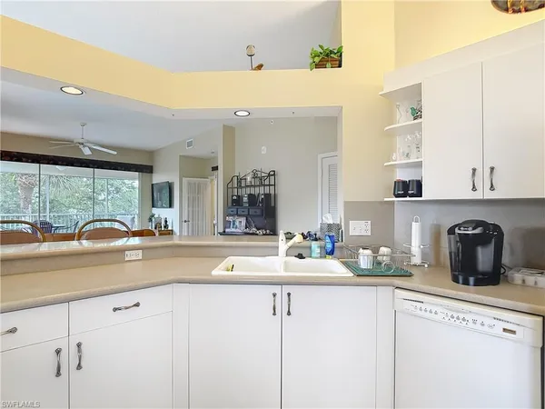 a kitchen with sink cabinets and living room view