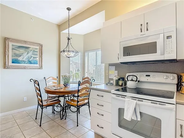 a kitchen with granite countertop cabinets a table and chairs in it