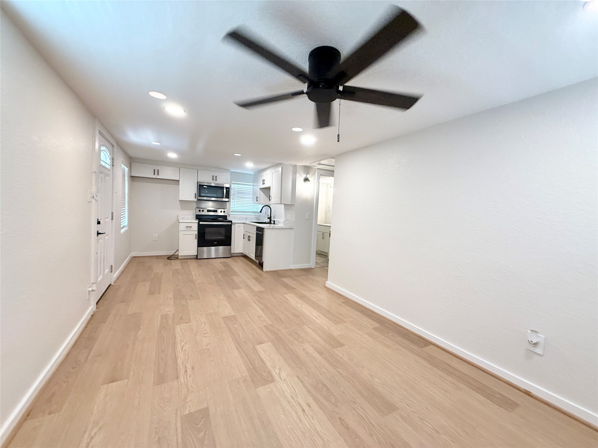 738 Caisson Street Surfside Beach, TX 77541 - Photo 6 of 19 an empty room with kitchen and windows