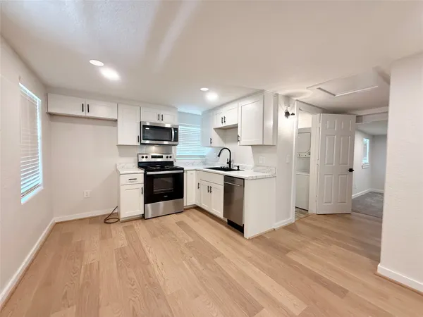a kitchen with granite countertop a refrigerator and a stove top oven