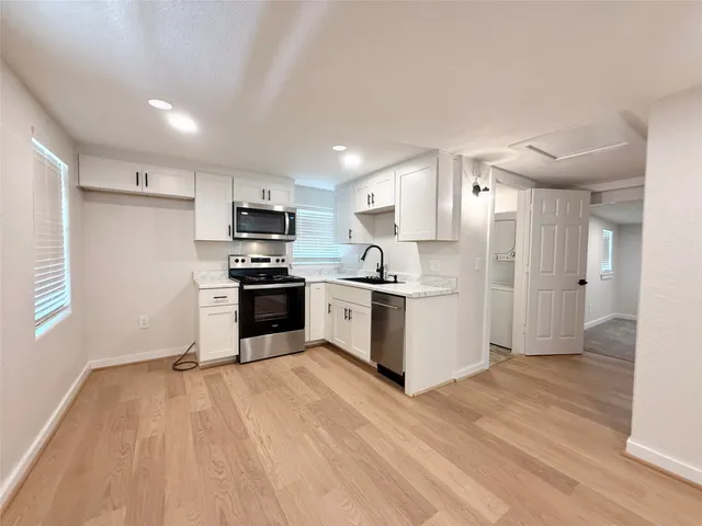 a kitchen with granite countertop a refrigerator and a stove top oven