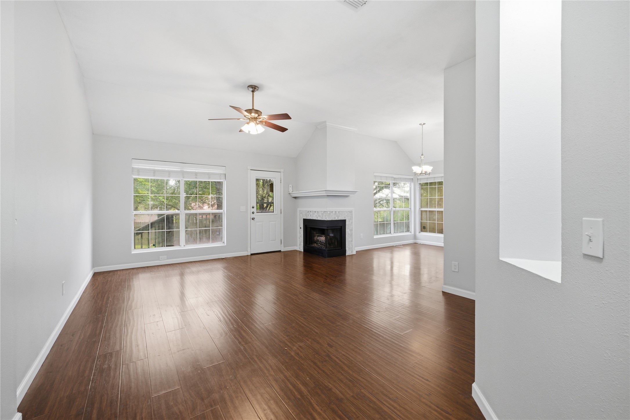 2922 Wickersham Lane Austin, TX 78741 - Photo 20 of 26 an empty room with wooden floor fireplace and windows