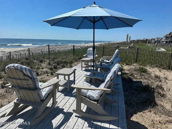 a view of a roof deck with couches under an umbrella