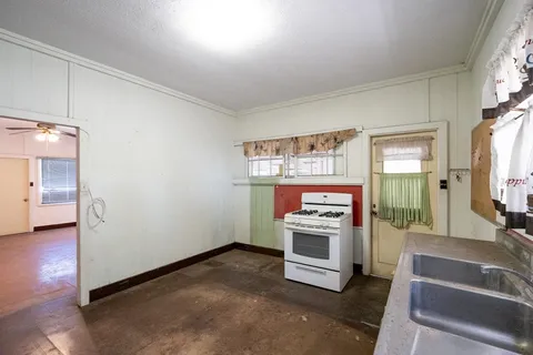 a living room with stainless steel appliances furniture a fireplace and a flat screen tv