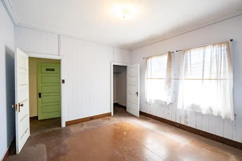 an empty room with windows and closet