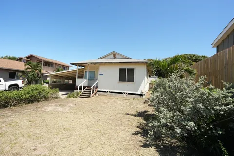 a white house that has a tree in front of it