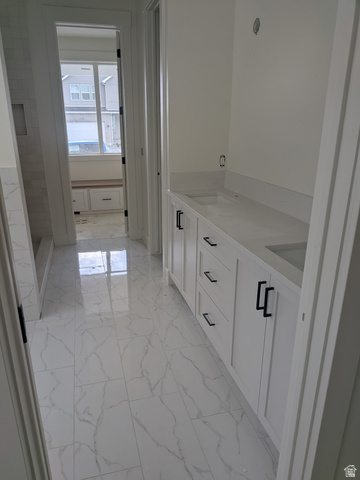 2771 West Aurora Avenue Mapleton, UT 84664 - Photo 6 of 39 Bathroom featuring white shaker cabinetry with matte black hardware, dual undermount sinks, and light-toned countertops