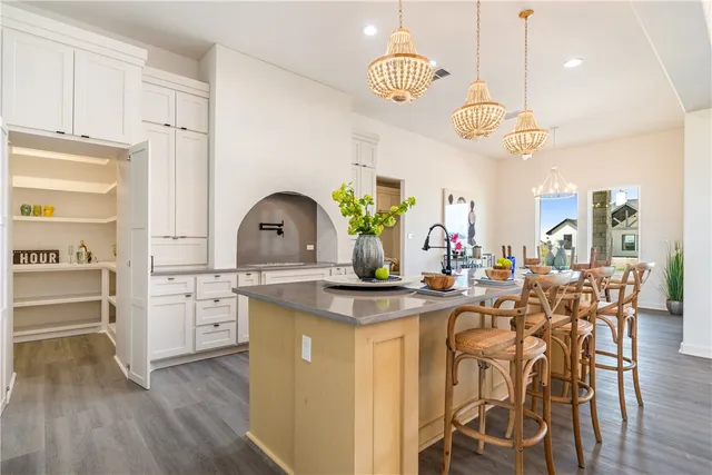 an empty room with wooden floor ceiling fan and windows