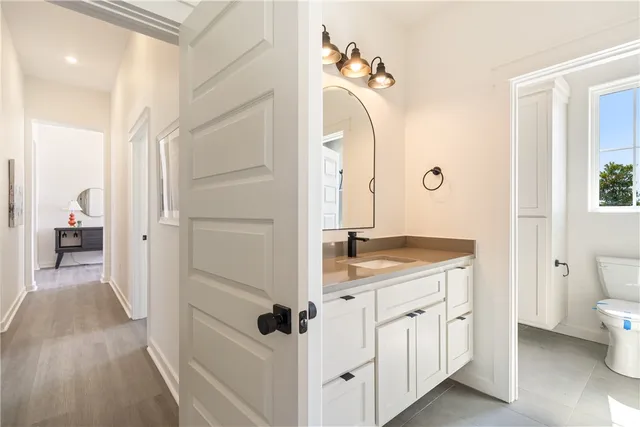 an empty room with wooden floor and ceiling fan