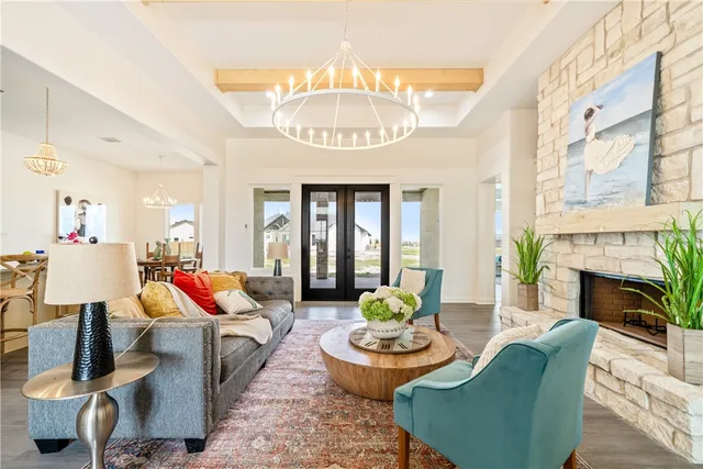 a living room with furniture a fireplace and a chandelier
