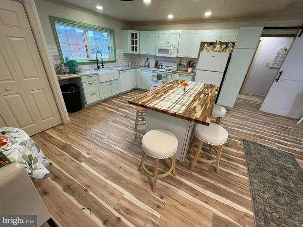 a kitchen with a table chairs sink and cabinets