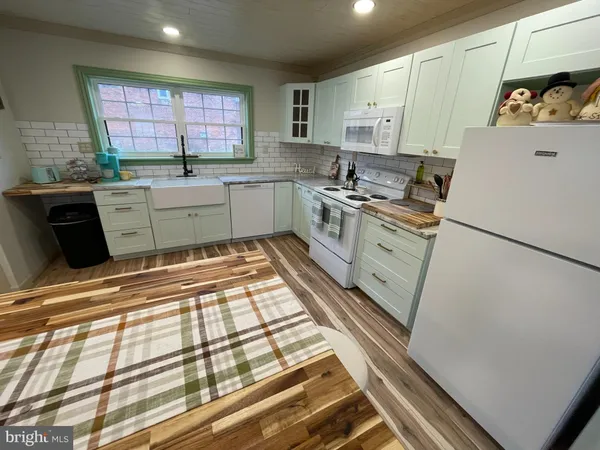a kitchen with stainless steel appliances granite countertop a refrigerator sink and white cabinets