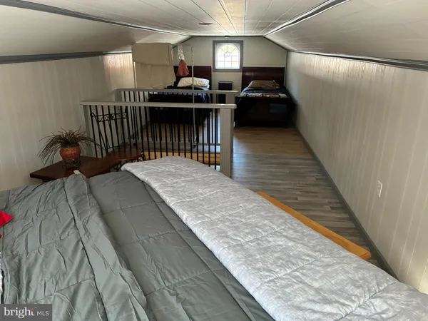 a bed sitting in a bedroom next to a window with wooden floor