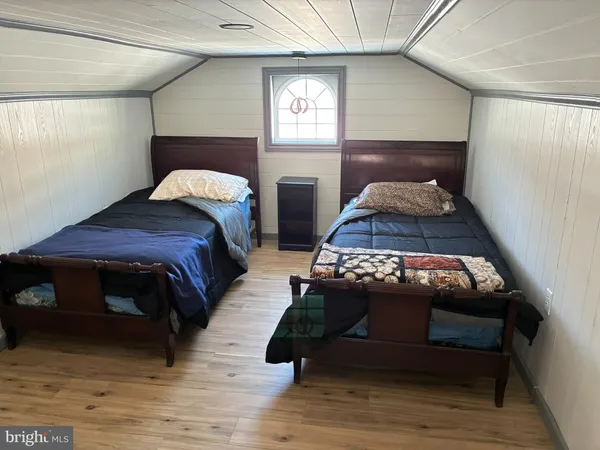 a bedroom with a bed and flat tv screen on the dresser