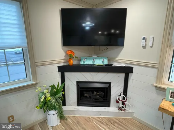 a living room with a fireplace and a potted plant