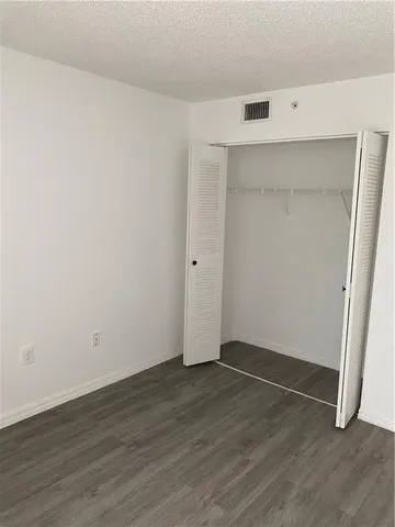 an empty room with wooden floor and white walls