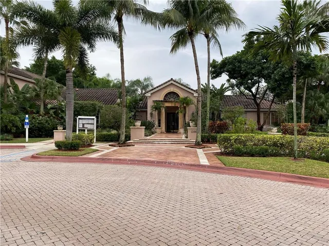 a view of a house with a yard and palm trees