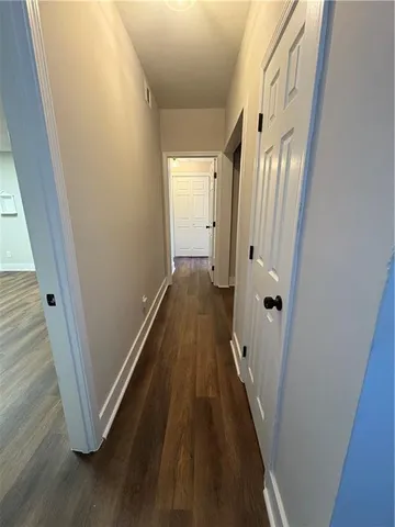 a view of a hallway with wooden floor and staircase