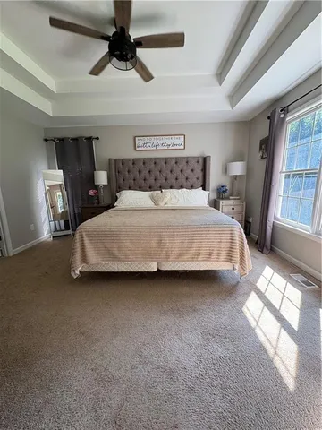 a bedroom with a bed a chandelier and a window