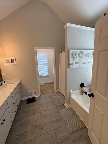 a bathroom with a tub sink and mirror