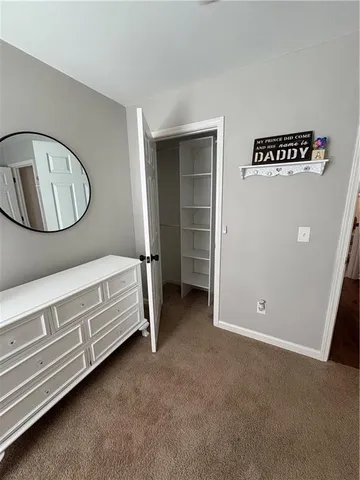 an empty room with a chandelier fan and windows