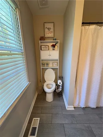 a view of a bathroom with closet and mirror