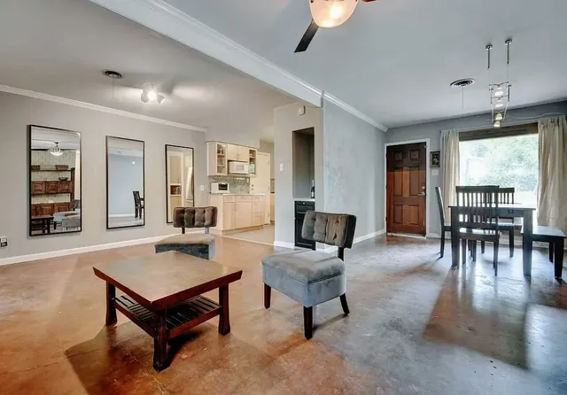 a living room with furniture a table and kitchen view