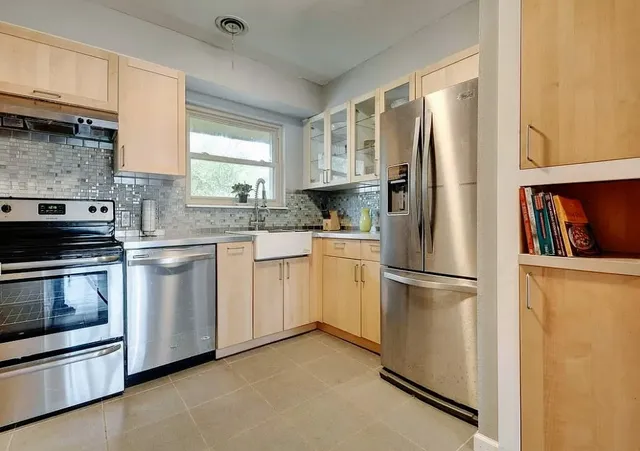 a kitchen with white cabinets and stainless steel appliances