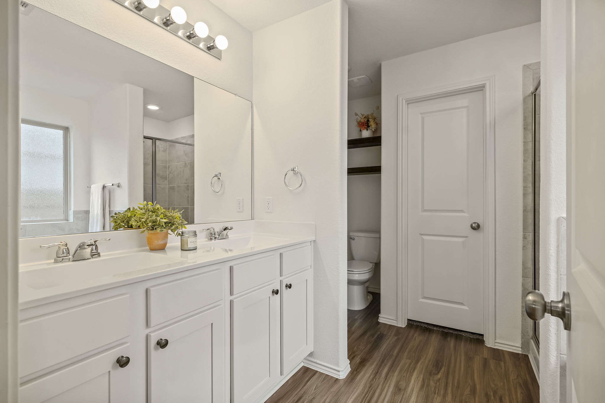 3489 Pauling Loop Round Rock, TX 78665 - Photo 10 of 32 The primary bathroom has two sinks, a walk-in closet, and vinyl floors