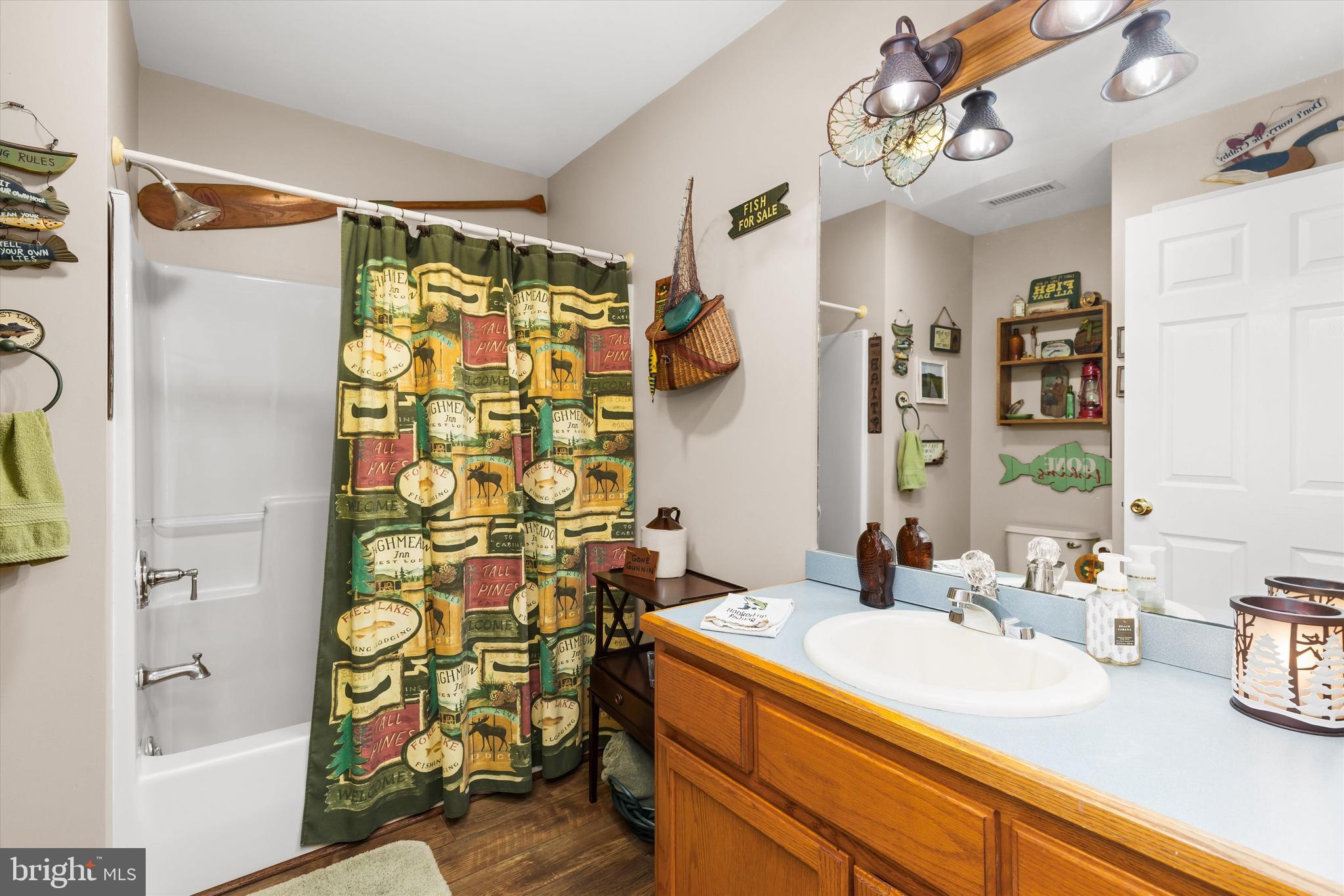 3620 Country Club Road Crisfield, MD 21817 - Photo 20 of 62 a bathroom with a granite countertop sink a mirror and shower curtain