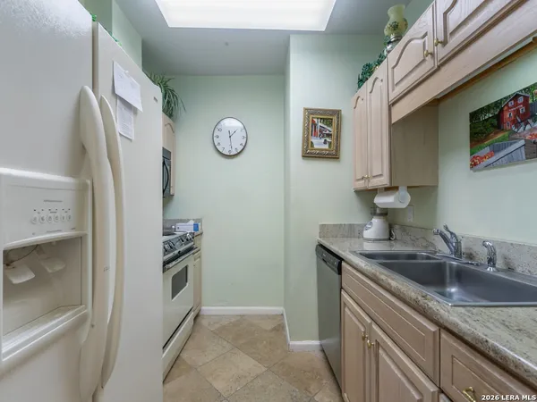 a kitchen with stainless steel appliances granite countertop a sink and a refrigerator