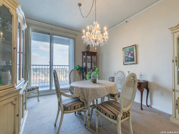 a view of a dining room with furniture a chandelier and wooden floor