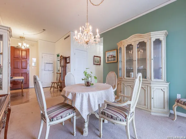a view of a dining room with furniture a chandelier and wooden floor