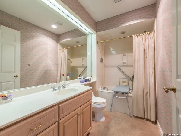 a spacious bathroom with a double vanity sink toilet mirror and bathtub