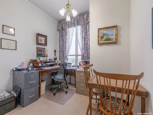 a view of a workspace with furniture and a window