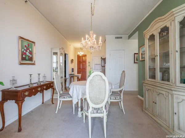 a dining room with furniture a chandelier and window
