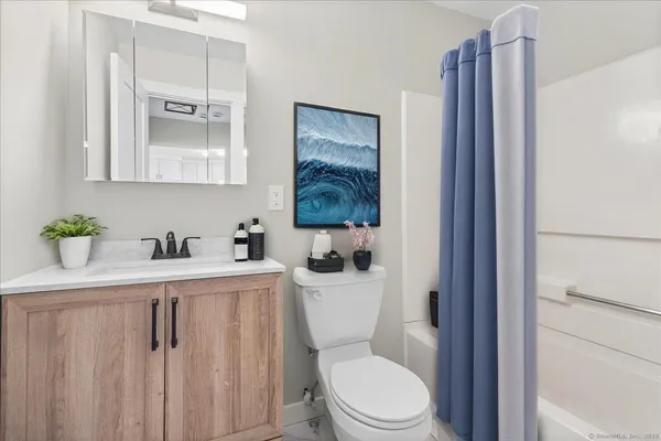 a bathroom with a toilet a sink and mirror