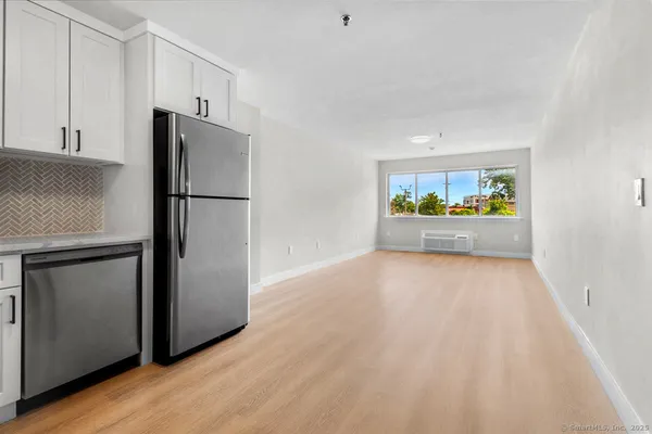 a view of kitchen with refrigerator stove and wooden floor