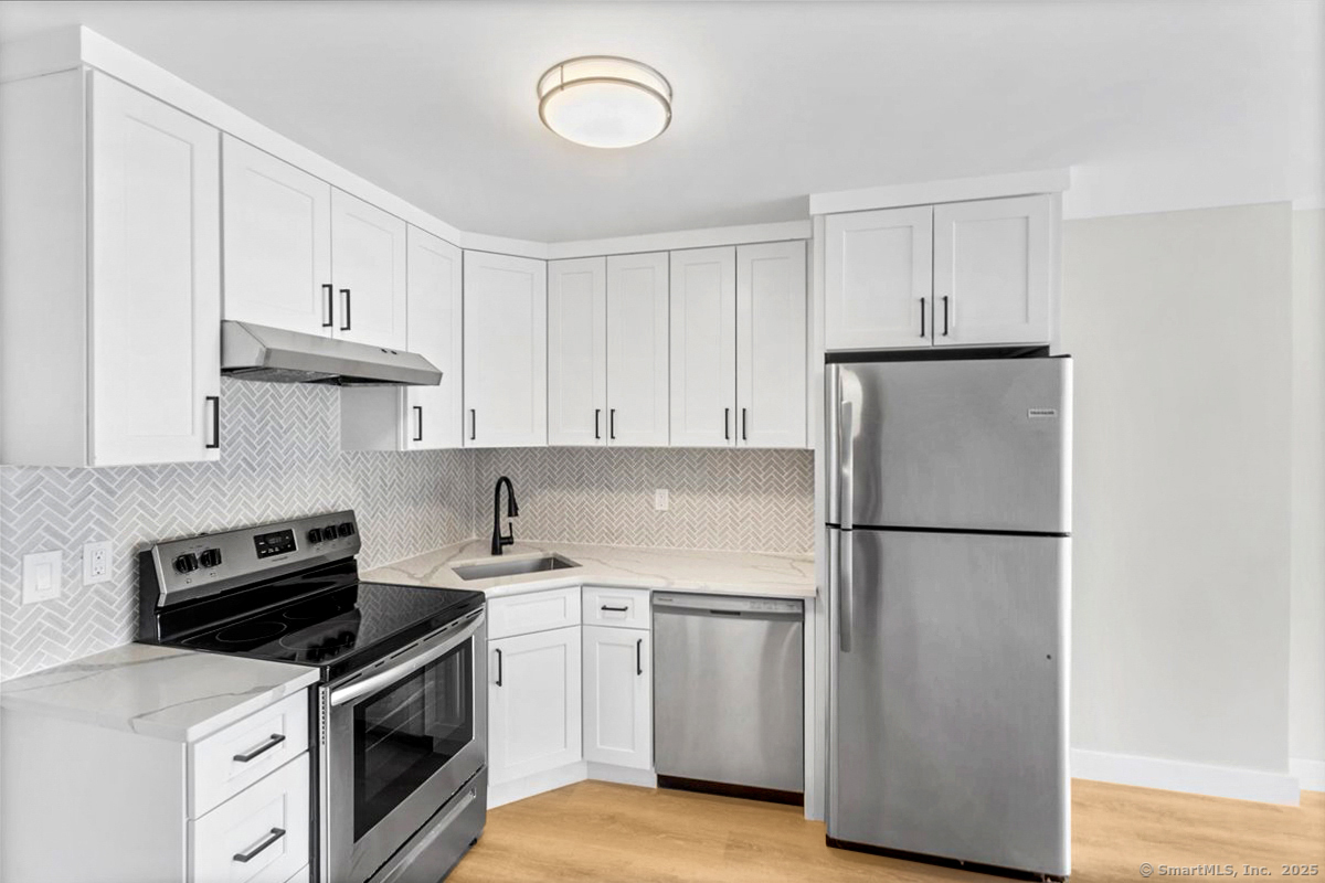 135 Gold Star Highway, Unit 407 Groton, CT 06340 - Photo 8 of 15 a kitchen with a white cabinets and white appliances